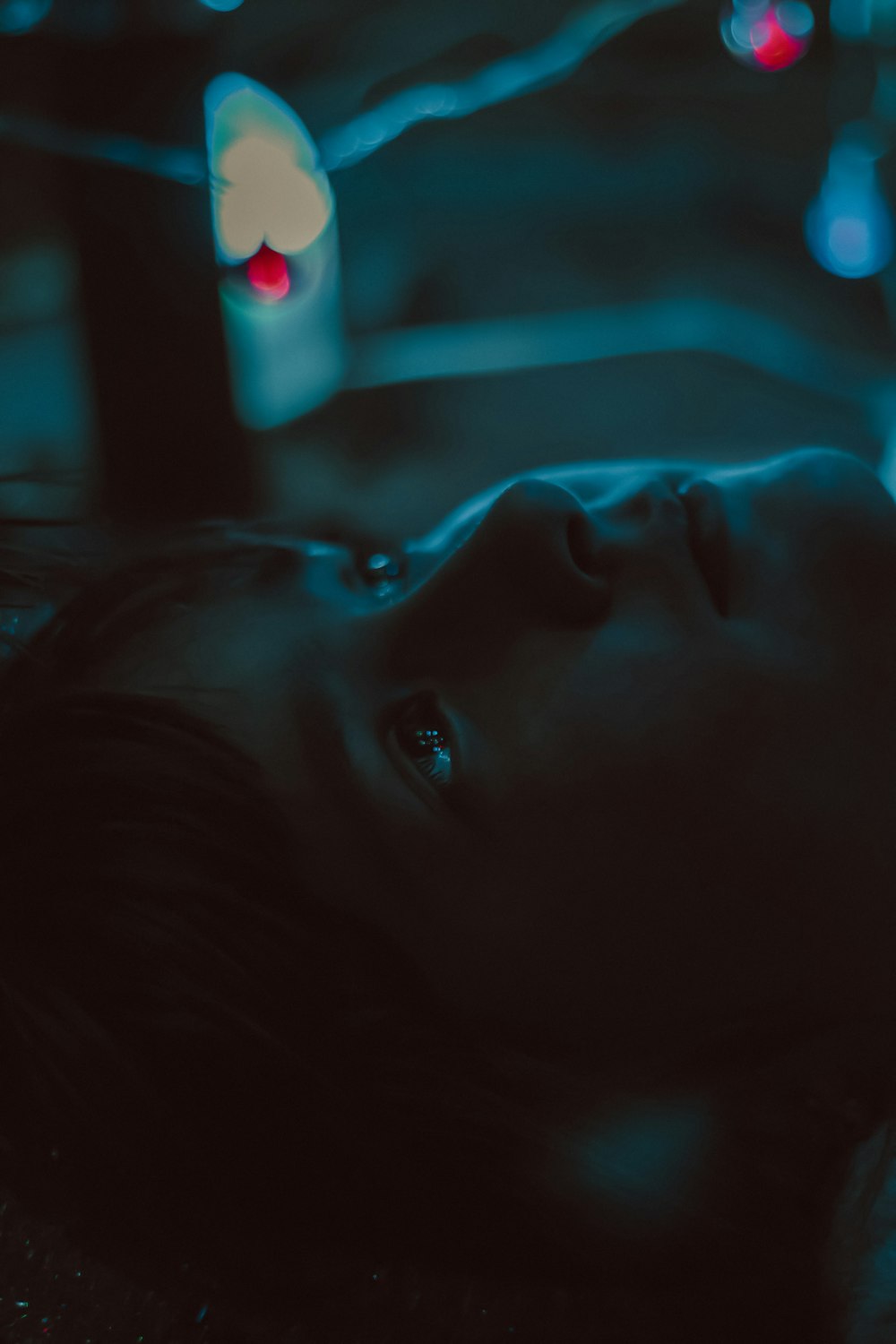 a young girl laying on the ground in the dark