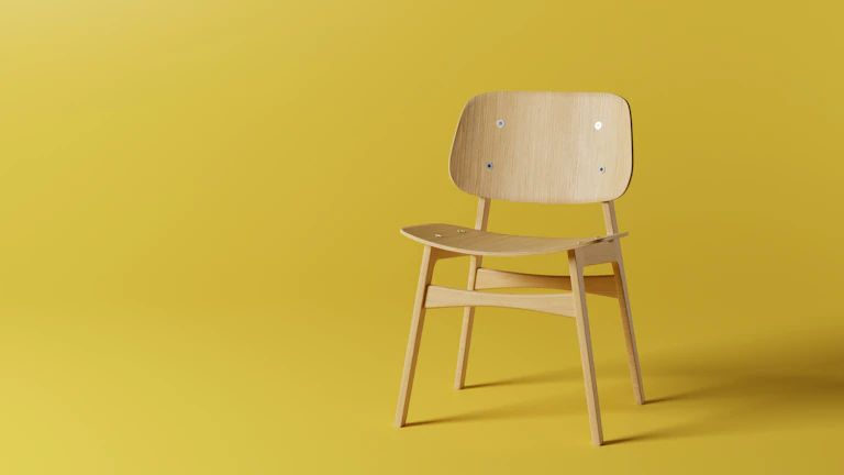 Bright minimalistic wooden chair with clean lines in a sunlit gallery space.