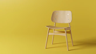 A sleek custom olive green and black wooden chair with clean lines, set against a minimalist white background.