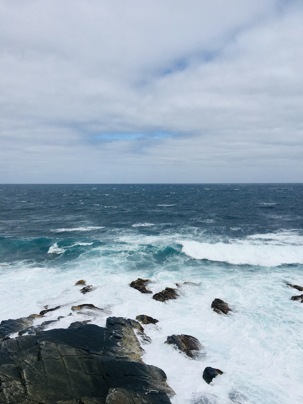 a large body of water sitting next to a rocky shore