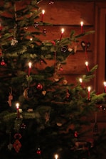 A warm holiday background featuring a decorated tree and glowing candles.