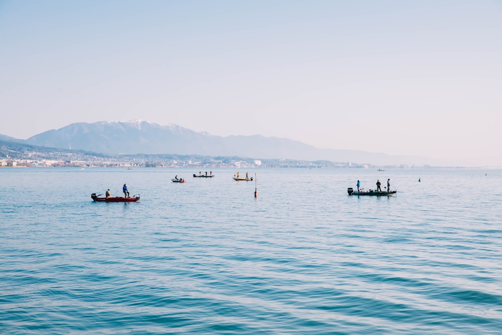 Eine Gruppe von Booten, die auf einem großen Gewässer schwimmen