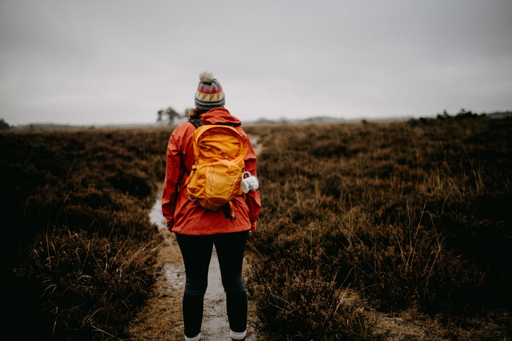 a person in a red jacket and a yellow backpack