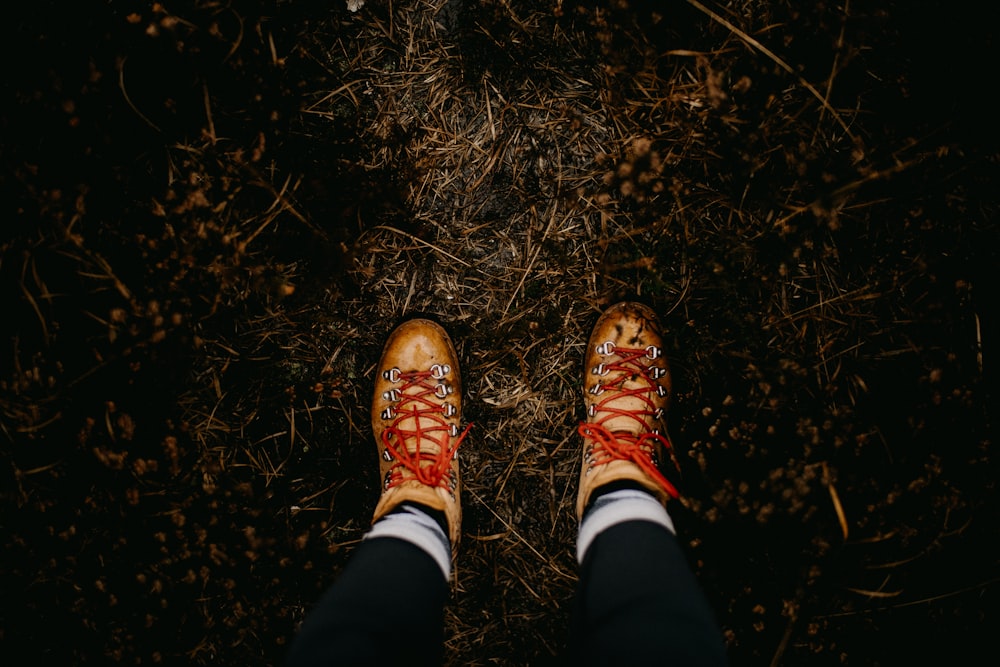 uma pessoa vestindo sapatos vermelhos em pé em um campo