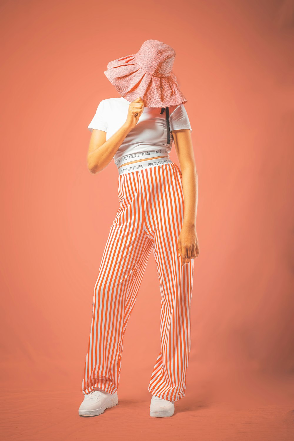 a woman in striped pants and a pink hat