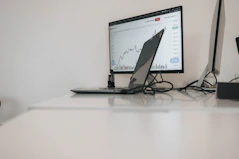 a desk with a laptop and a monitor on it