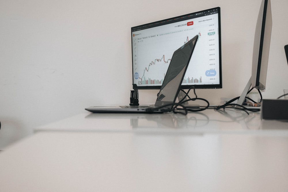 a desk with a laptop and a monitor on it