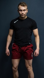 a man in a black shirt and red shorts