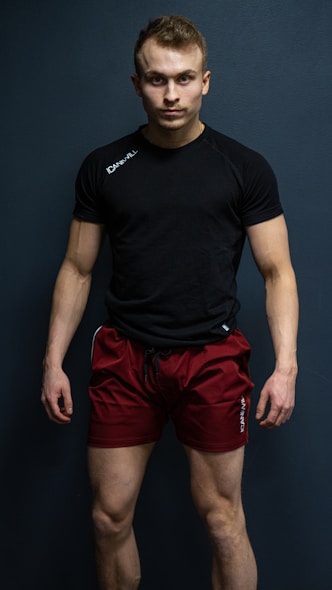 a man in a black shirt and red shorts