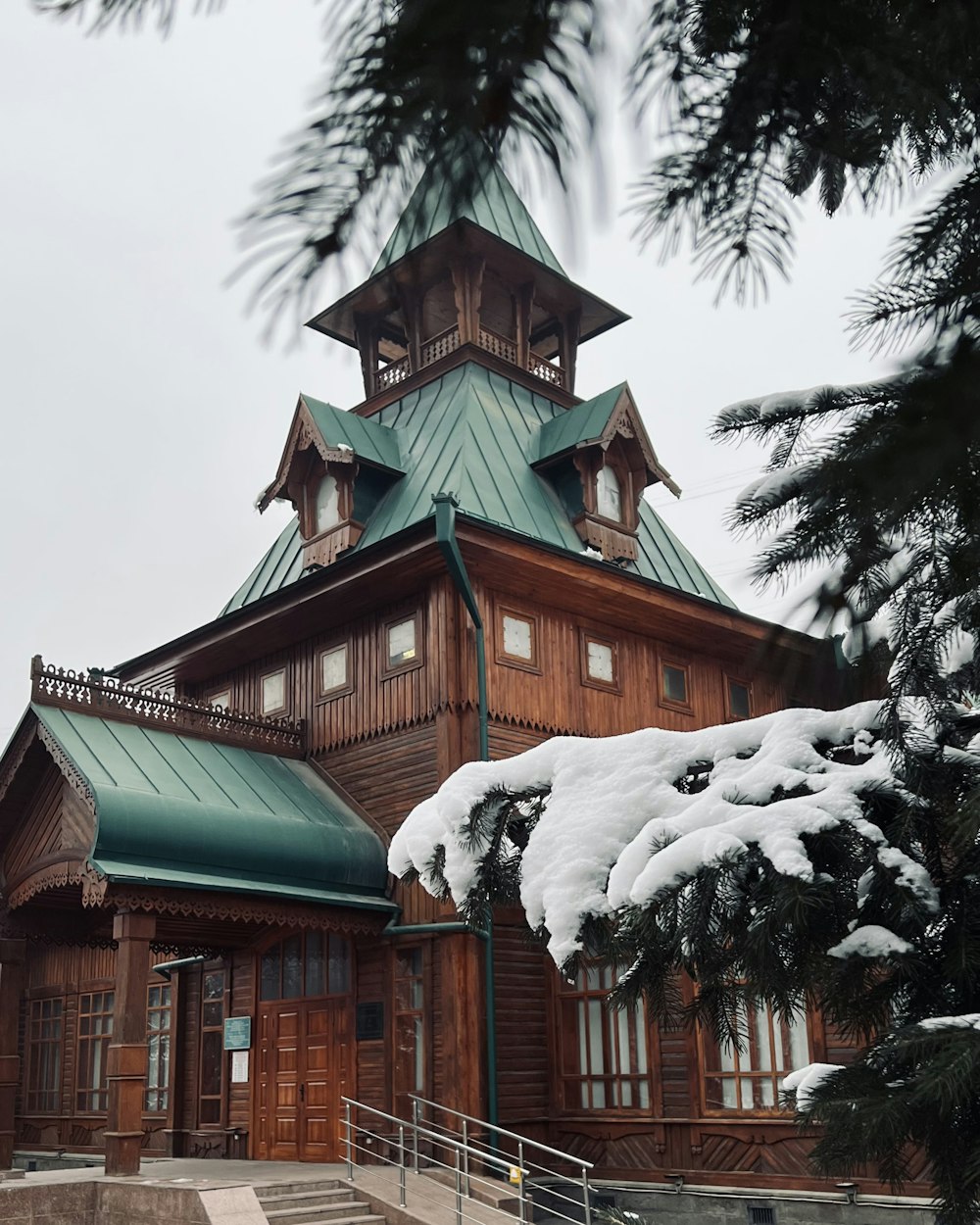 a large wooden building with a green roof