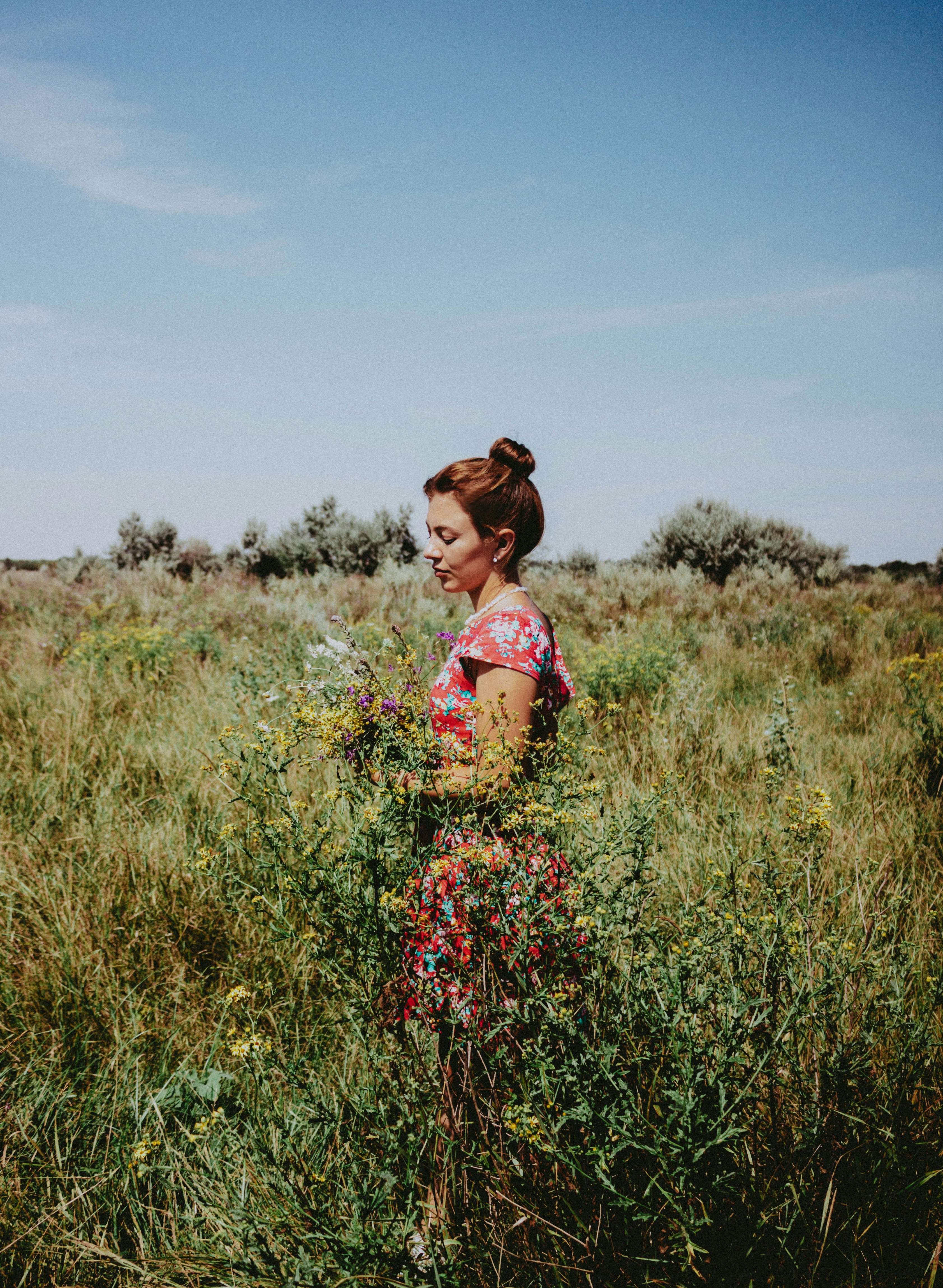 a woman standing in a field of tall grass