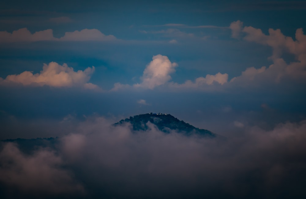 a view of a mountain in the middle of the clouds