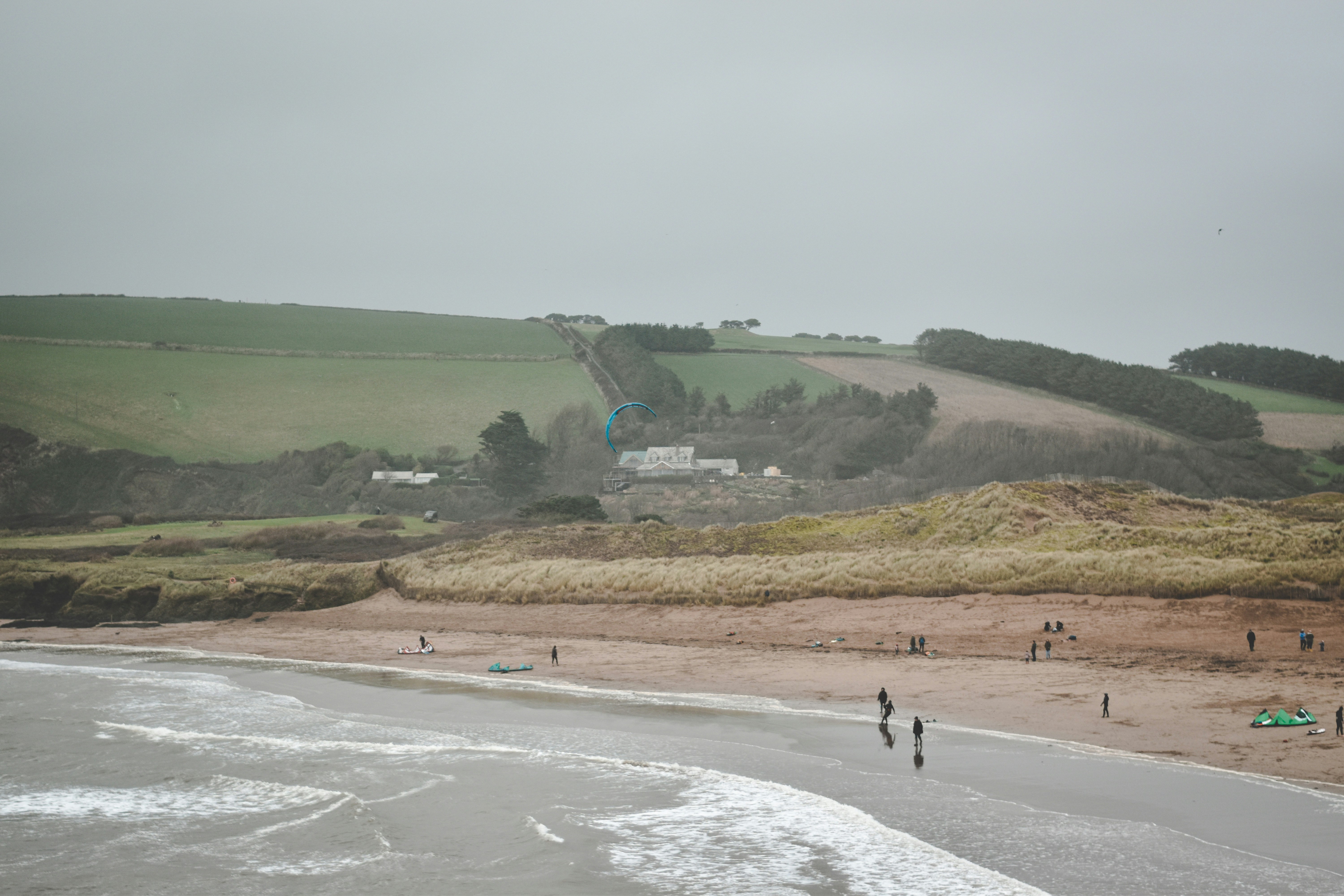 a group of people standing on top of a sandy beach