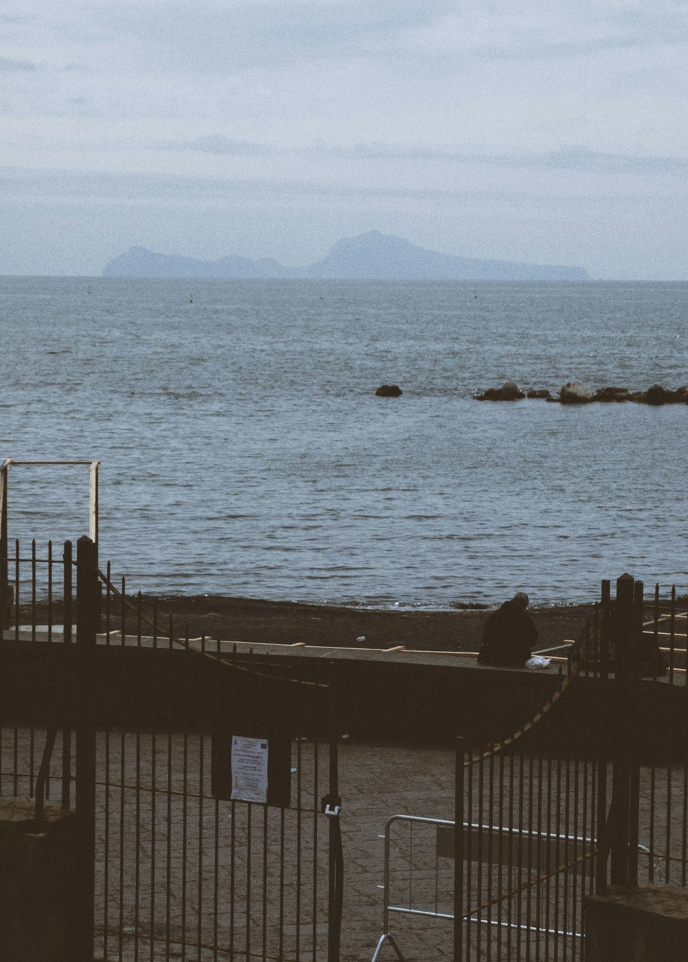 a bike parked next to a fence near a body of water