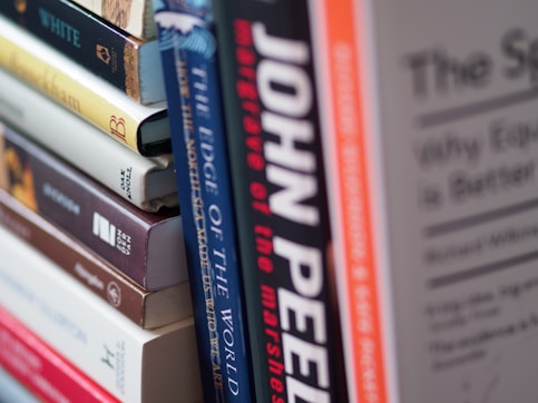 a stack of books sitting on top of a shelf