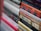 A stack of books with various titles is shown, featuring religious and spiritual themes. The spines are vertically aligned, showcasing different fonts and colors. Some titles include words like 'God' and 'Devotional,' suggesting content related to theology or religious studies. The image is focused on the books in the foreground, with the background slightly blurred.