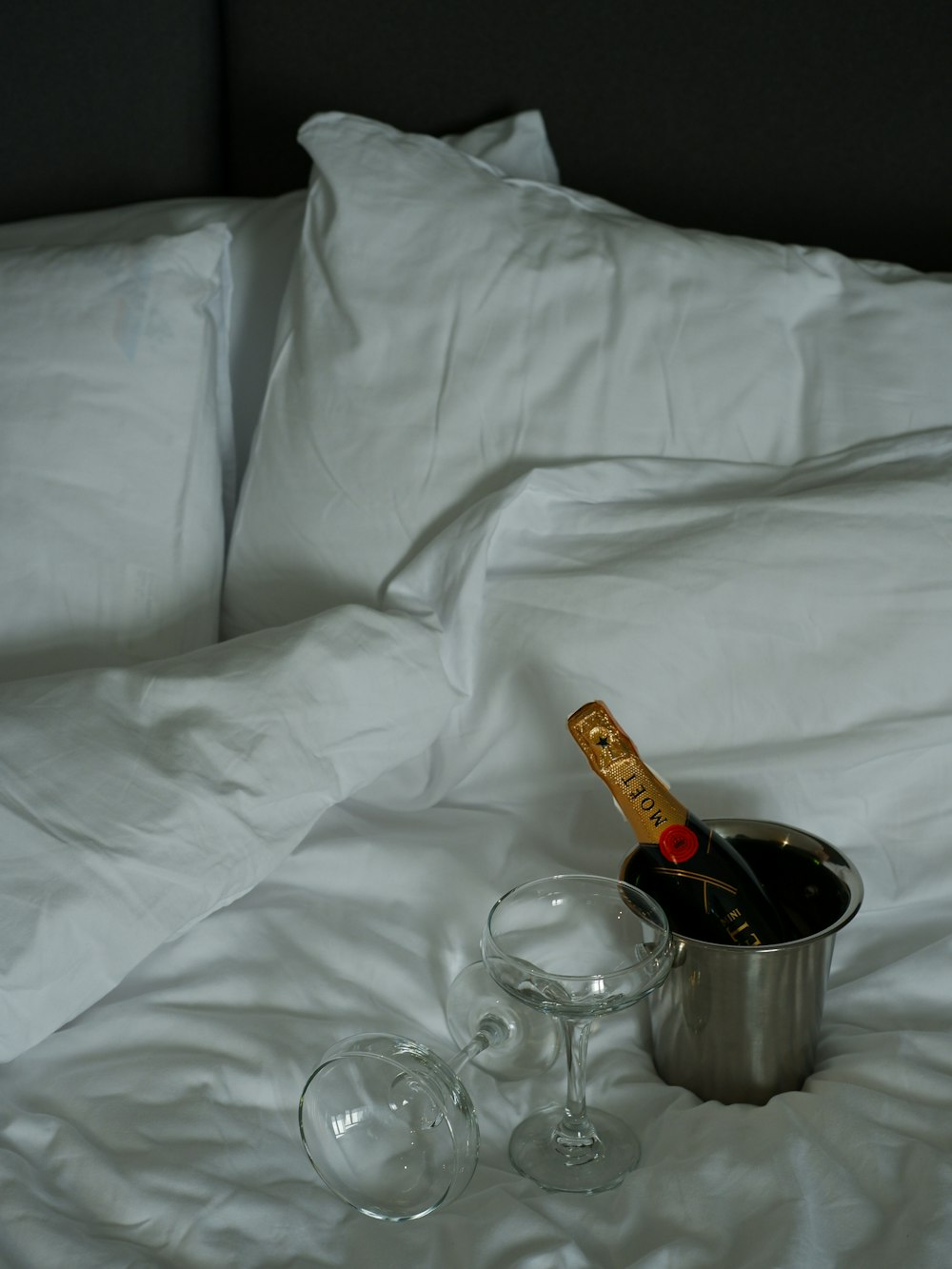 a bottle of champagne and two glasses on a bed