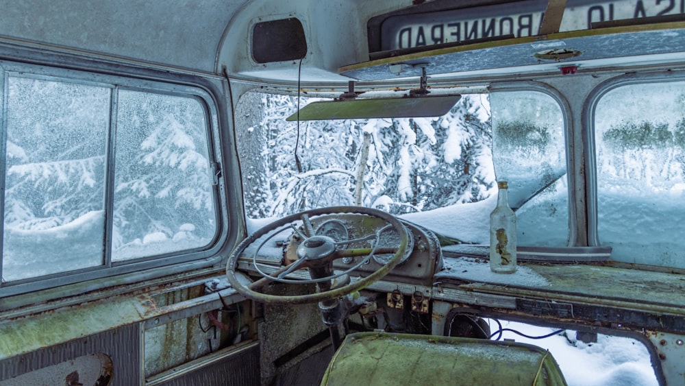 the interior of an old bus with snow on the ground