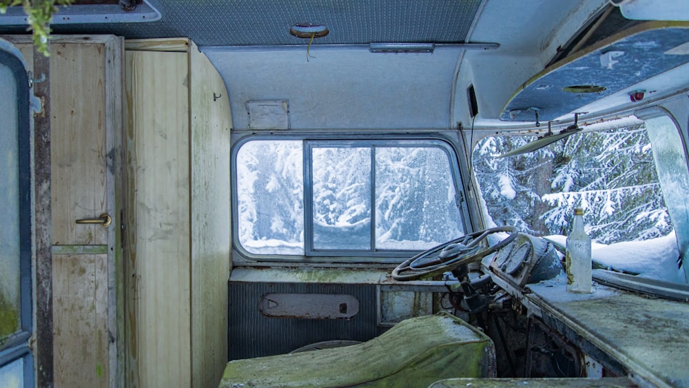 the interior of an old camper with snow on the ground