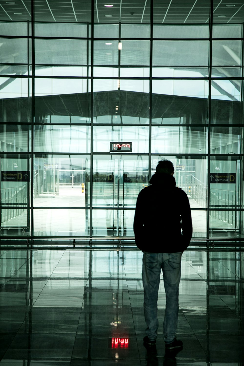 Ein Mann steht vor einem großen Glasgebäude