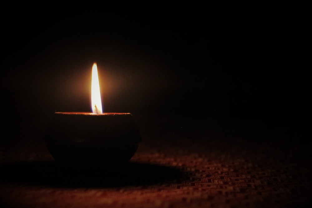 a lit candle sitting on top of a table