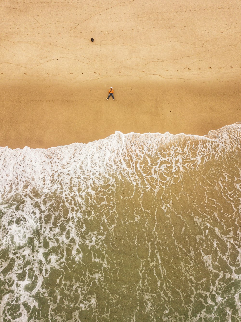 海の隣のビーチを歩いている人