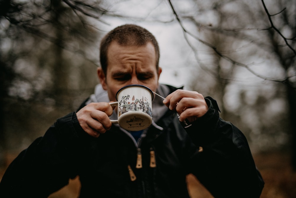 a man holding a coffee mug in front of his face