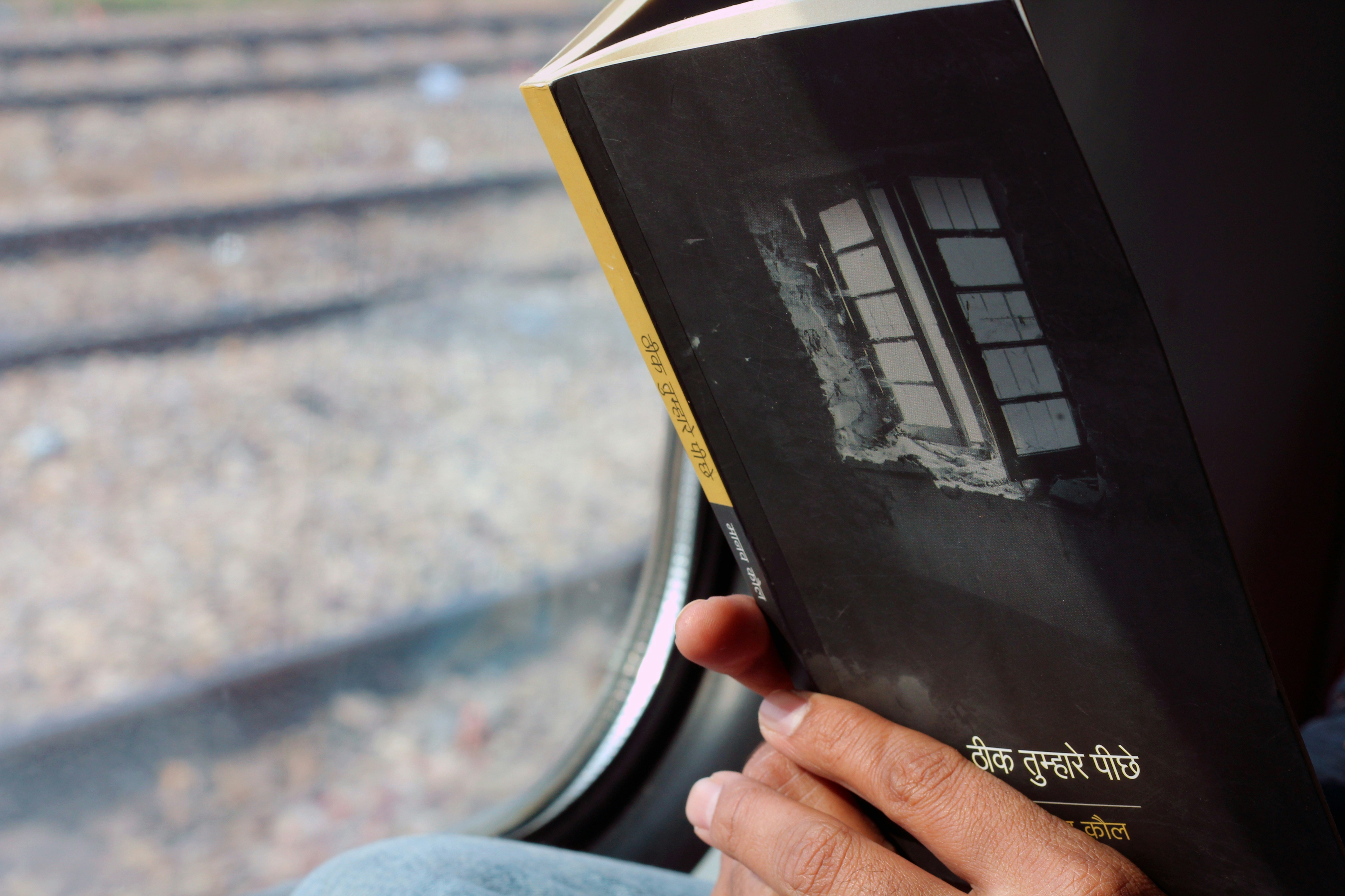 a person sitting on a train holding a book