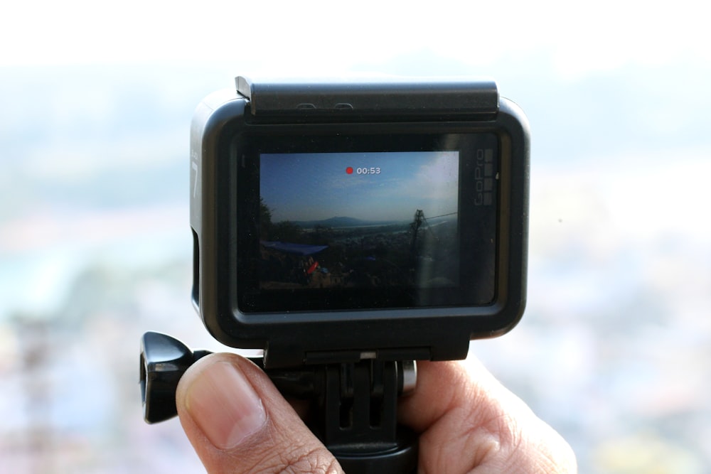 a person holding a camera with a view of a city