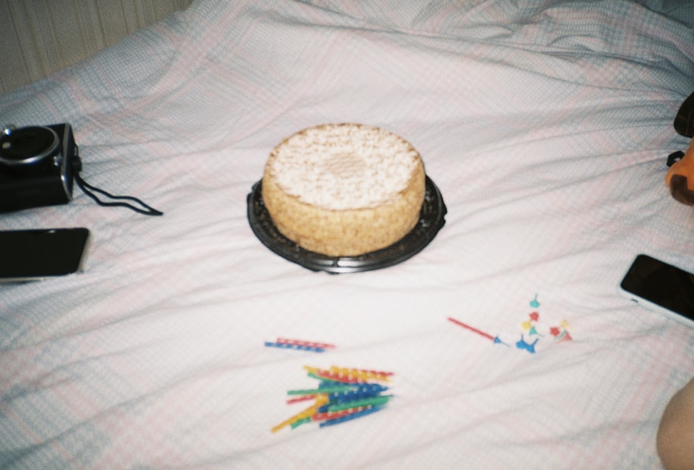 a cake sitting on top of a black plate on a bed