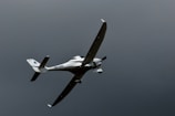 a small airplane flying through a cloudy sky