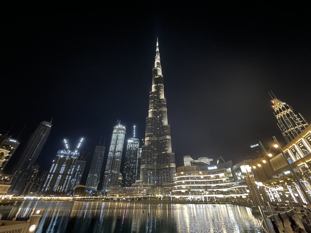 a very tall building towering over a city at night