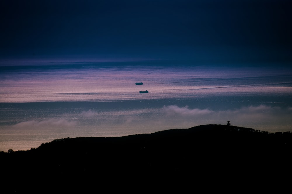 a couple of boats floating on top of a body of water