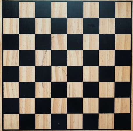 Close-up of a knight and queen on a wooden chessboard