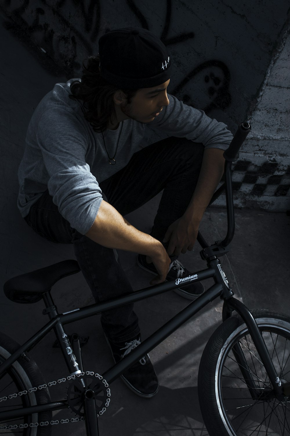 a man sitting on top of a bike next to a wall