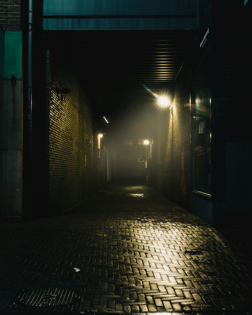a dark alley way with a light at the end