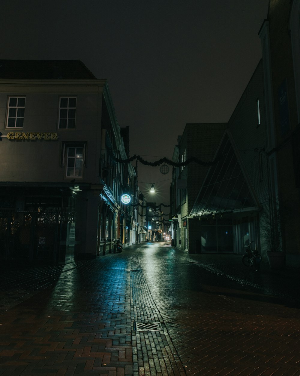 uma rua da cidade à noite com uma luz de rua acesa