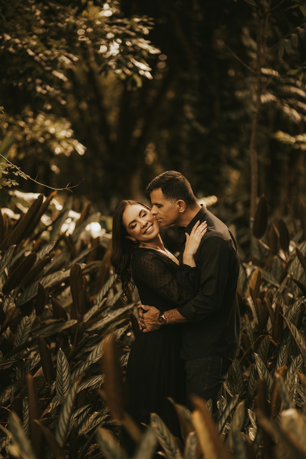 a man and a woman embracing in a field of plants