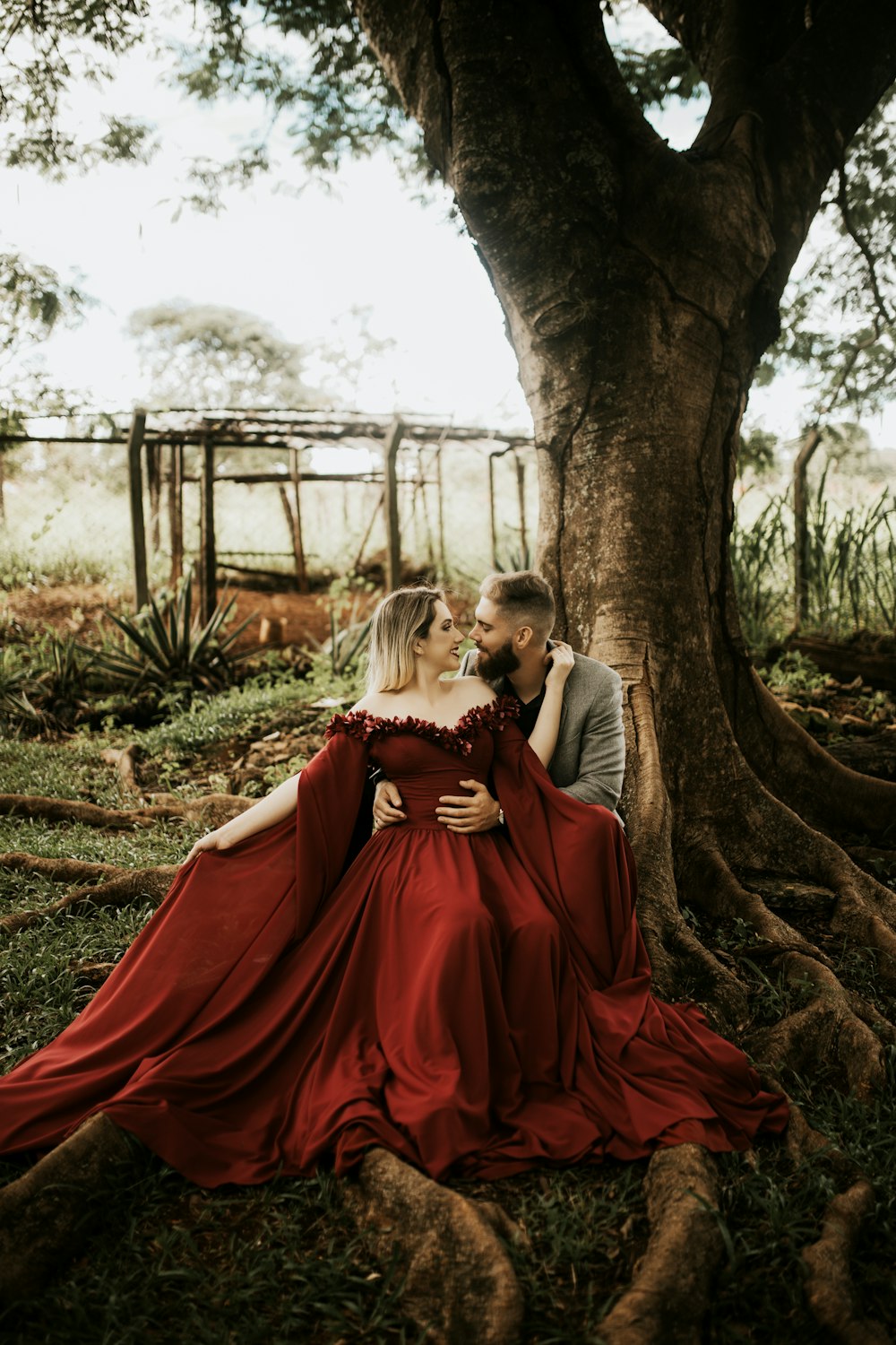 a man and a woman are sitting under a tree