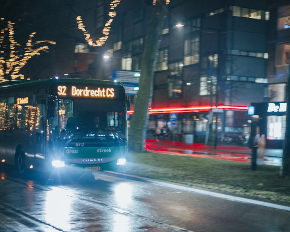 a bus driving down a street at night