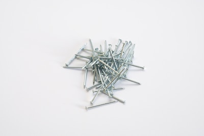 a pile of nails sitting on top of a white table