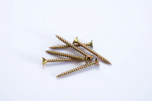 Close-up of shiny stainless steel screws neatly arranged on a clean white surface in the Wubi Screw factory.