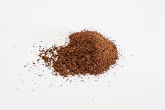 a pile of ground coffee sitting on top of a white table