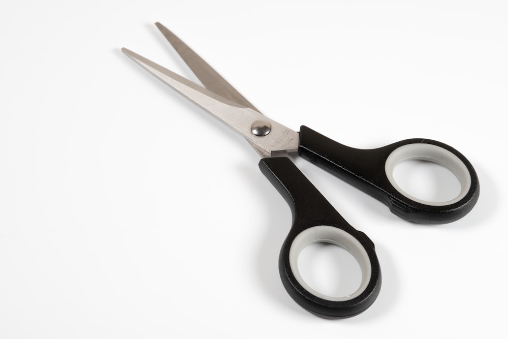a pair of scissors sitting on top of a white table