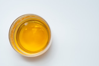 a glass filled with liquid sitting on top of a white table