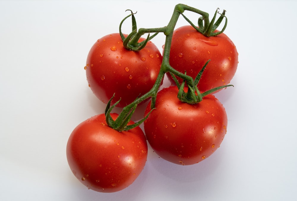 a group of three tomatoes sitting on top of a table