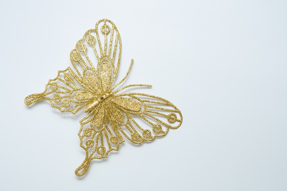 a gold butterfly brooch with intricate filigrees