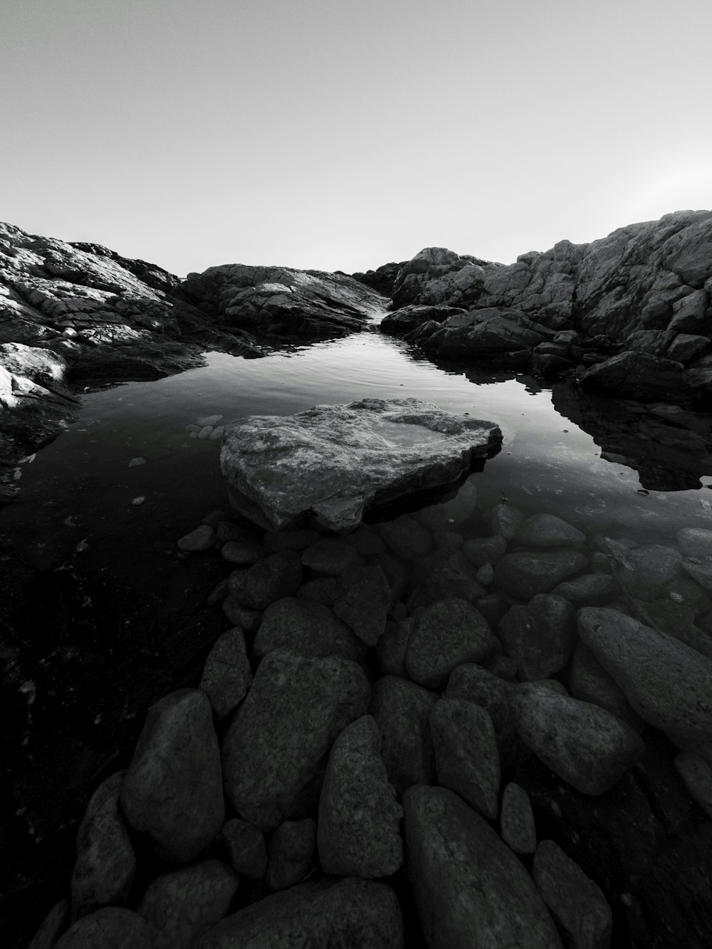 a black and white photo of rocks and water
