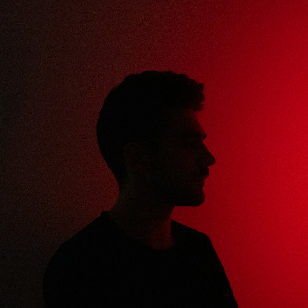 a man standing in front of a red light