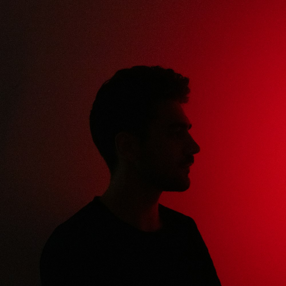 Un hombre parado frente a una luz roja